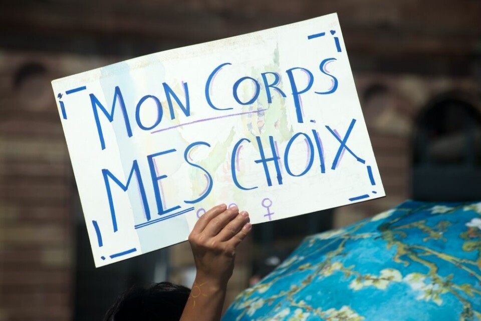 A protester holding a placard reading: ‘My body, my choices’ in French