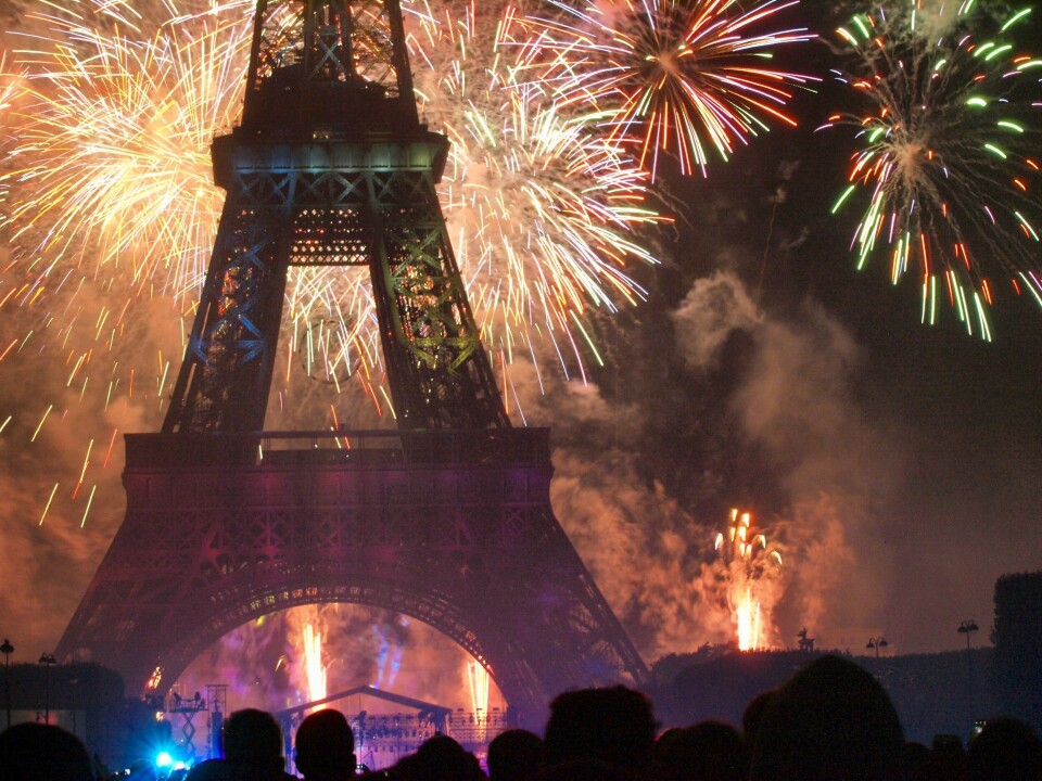 People watching fireworks above the Eiffel Tower in Paris, France, on July 14