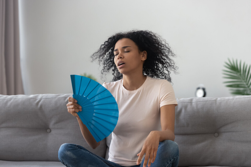 A woman using a fan in hot weather