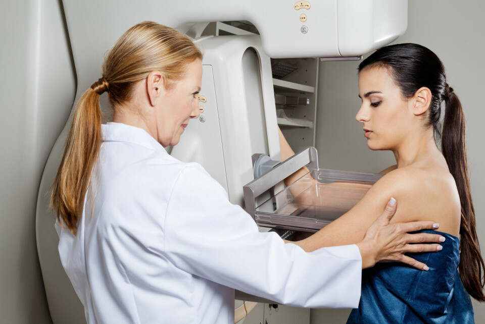 A woman getting a mammogram, being helped by a doctor