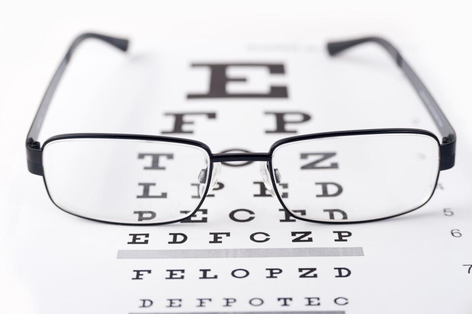 A photo of some glasses on top of an eye test chart