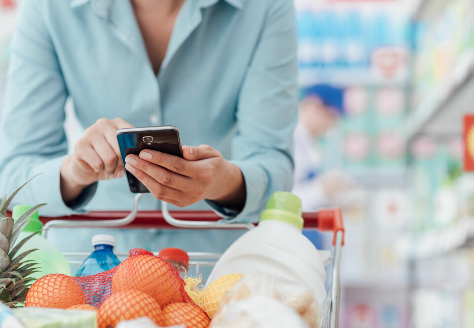 A woman using a smartphone in the supermarket