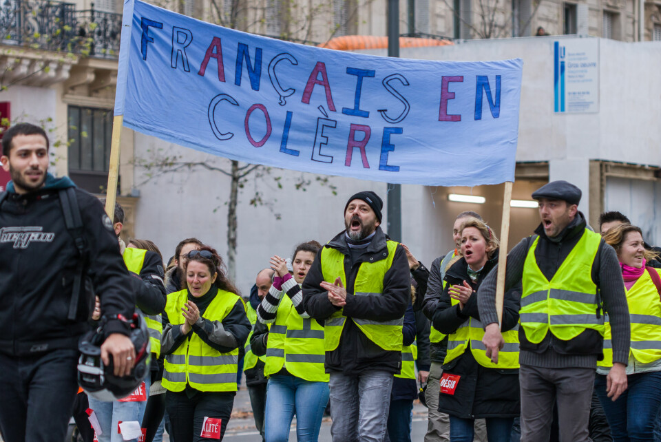 A photo of a gilet jaunes protesters carrying a banner in 2018