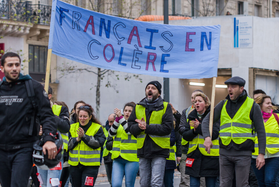 A photo of a gilet jaunes protesters carrying a banner in 2018