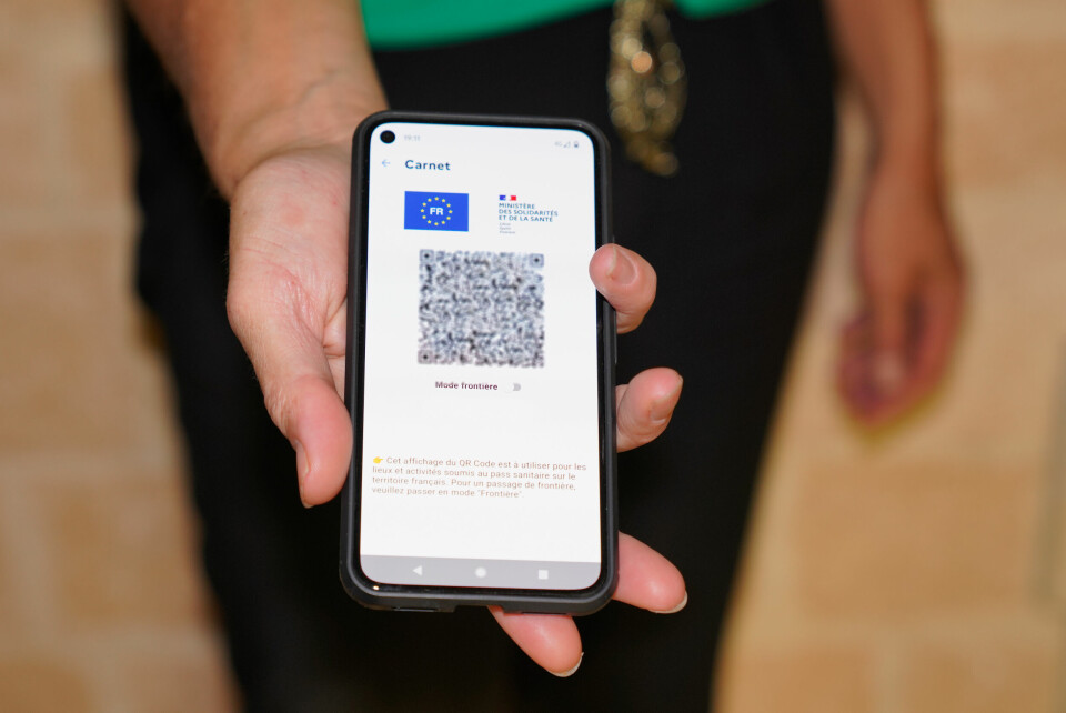 Health pass with QR code on a smartphone screen in hand