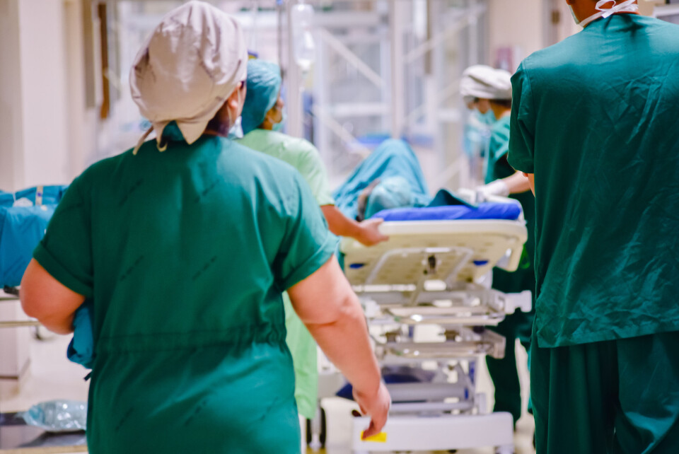 A photo of a medical team moving fast to move a patient on a bed