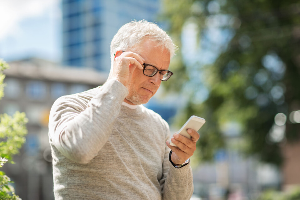 Ground Picture / Shutterstock A photo of an older man looking suspiciously at his phone