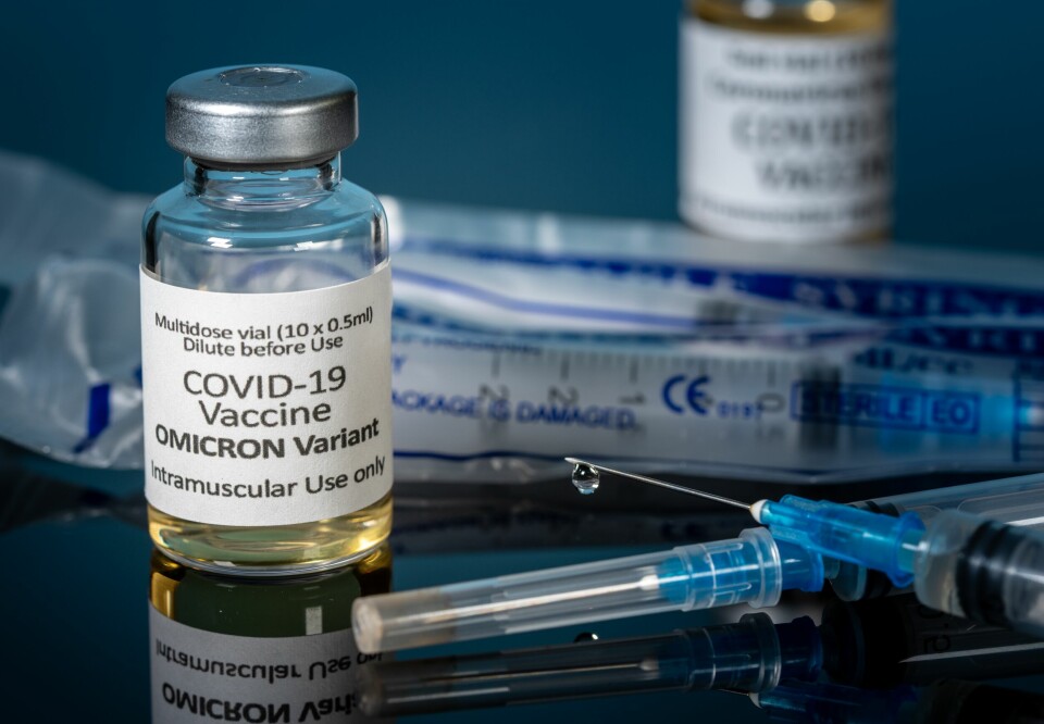 A close up photo of a clear vaccine vial with a label reading Covid-19 Vaccine Omicron Variant