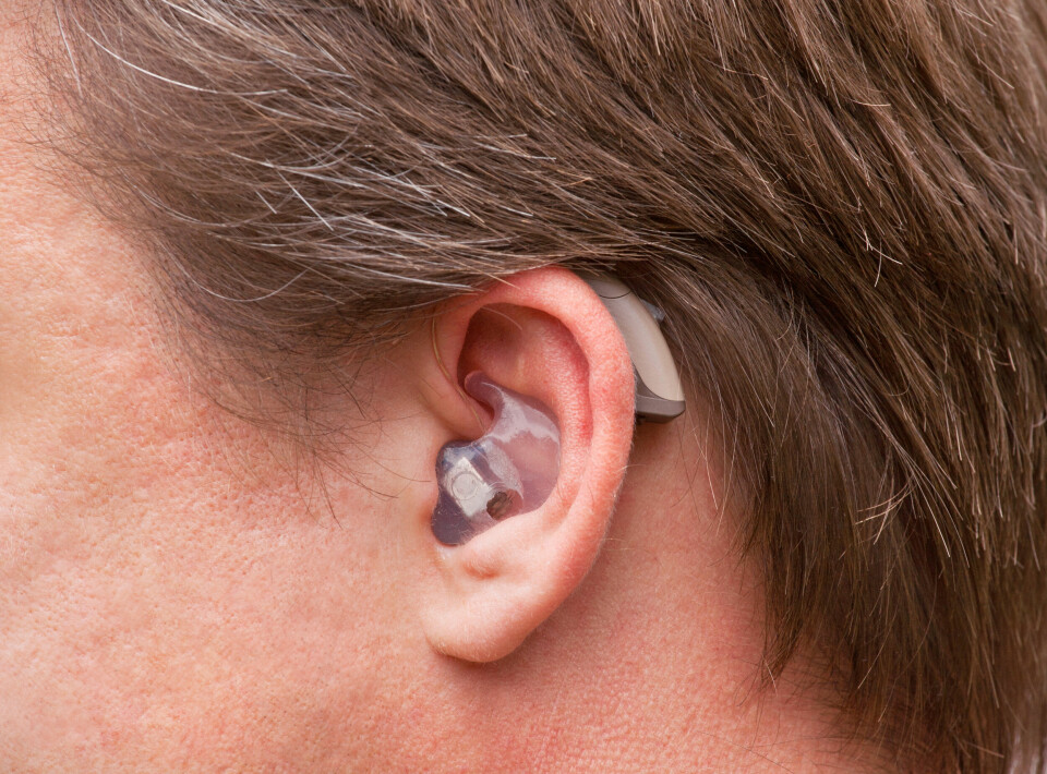 A close-up of a man wearing a hearing aid device