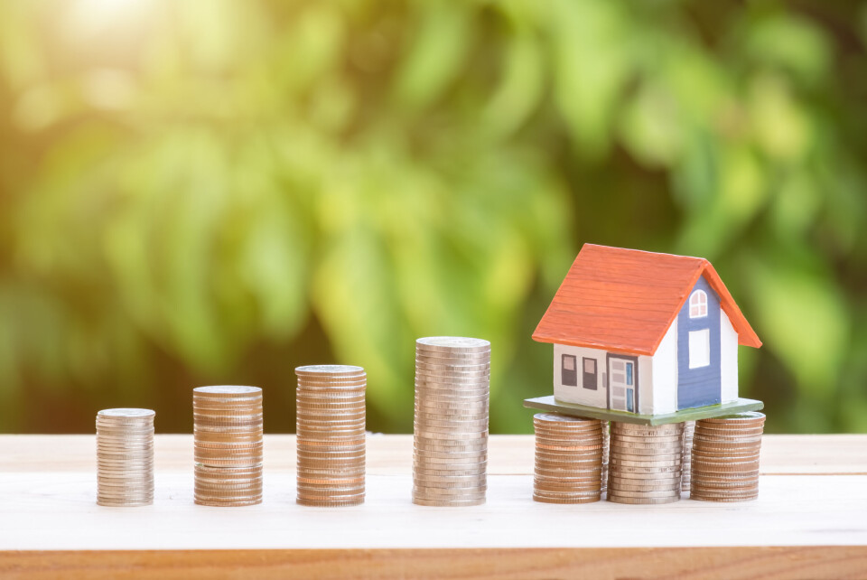 A photo of piles of coins and a model house to demonstrate property taxes