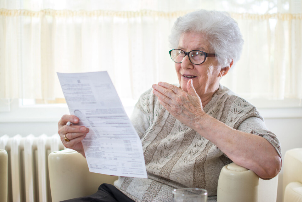 Bojan Milinkov / Shutterstock An older woman looking shocked while looking at a letter