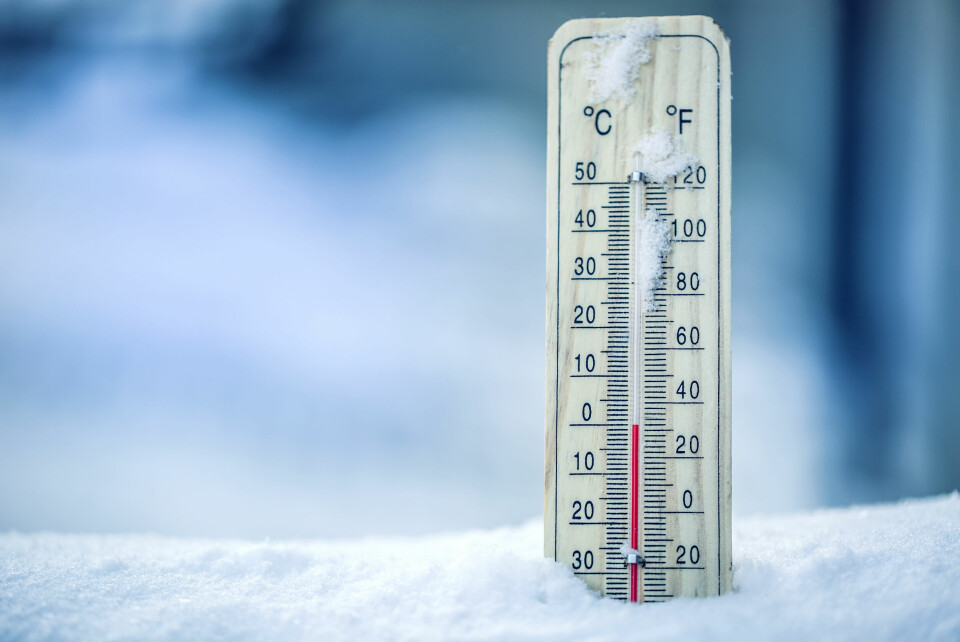 A photo of a thermometer showing 0C in snow