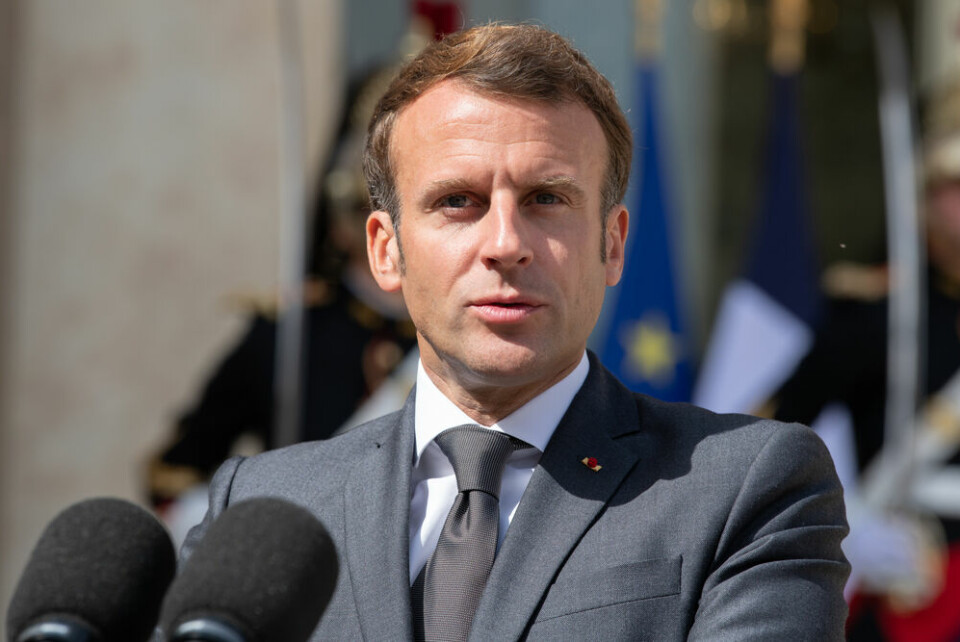 A photo of President Macron speaking into microphones