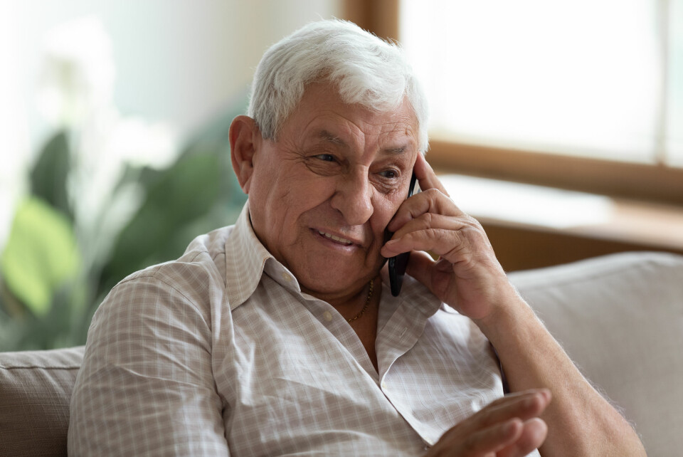 An image of a man in his 60s or 70s talking on the phone
