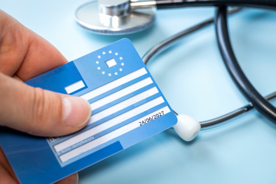 A European Health Insurance Card on a blue background with a stethoscope