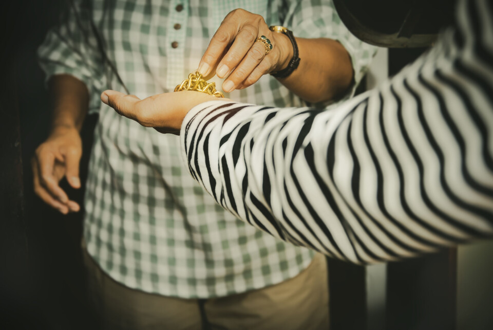 An older woman giving over jewelry to the thief