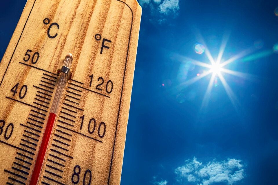 A thermometer reaching 40C under a sunny sky