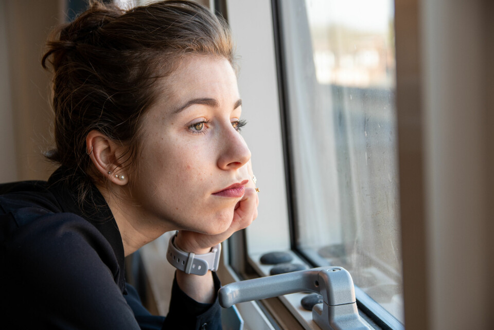 A woman looking fed up staring out of a window