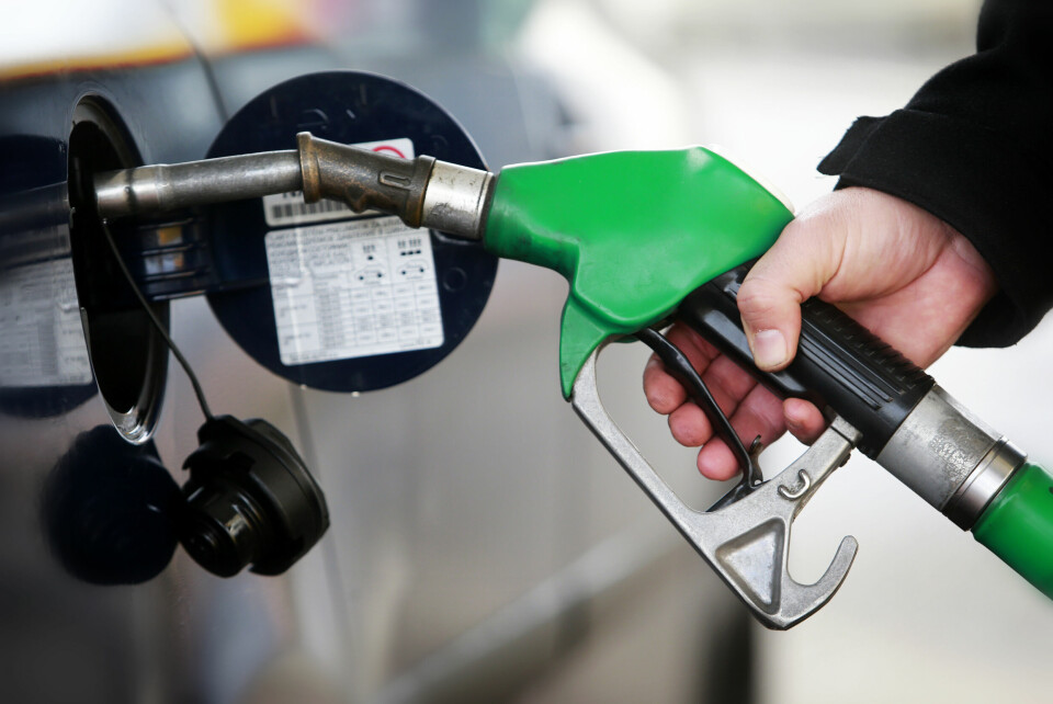 A photo of a man filling up a vehicle at a petrol pump