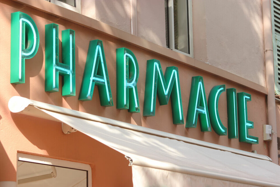 A pharmacy sign lit up on a wall