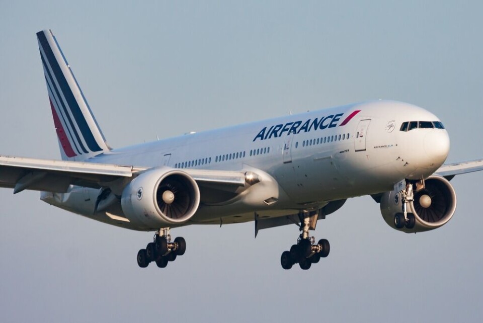 An Air France plane with its landing gear visible over Paris Charles de Gaulle airport