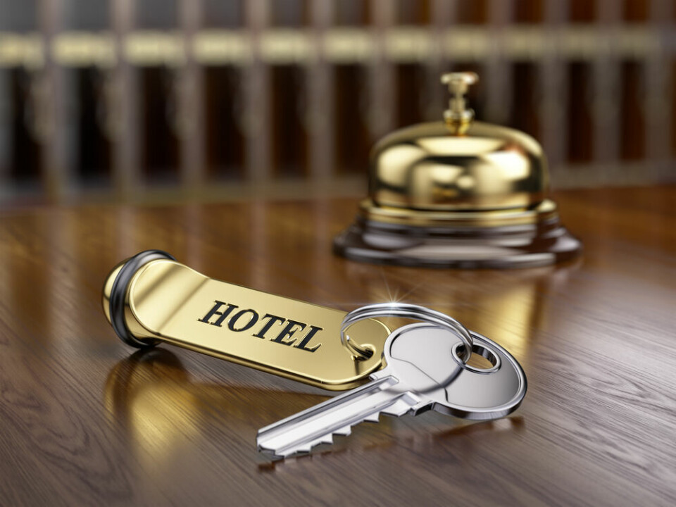A view of an old-fashioned gold hotel room key on a reception desk