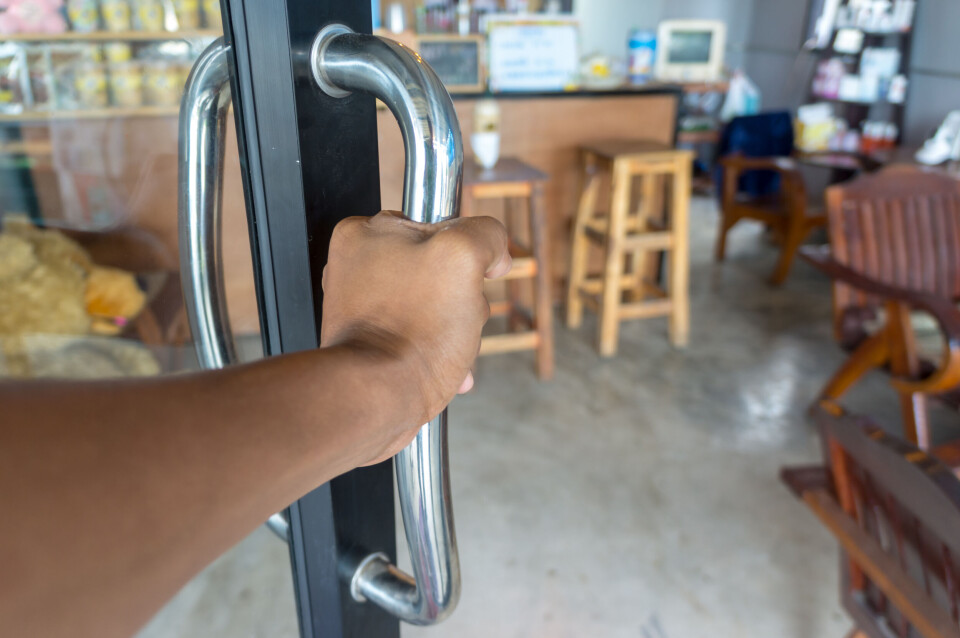 itthiphon suangam / Shutterstock A customer opens a door into a shop or coffee shop