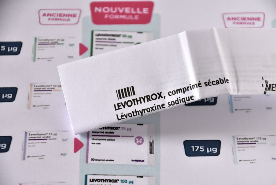 A hand holds the leaflet of the drug Levothyrox against papers comparing the old formula with the new one