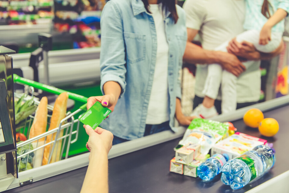 A woman handing over a card when shopping at a supermarket