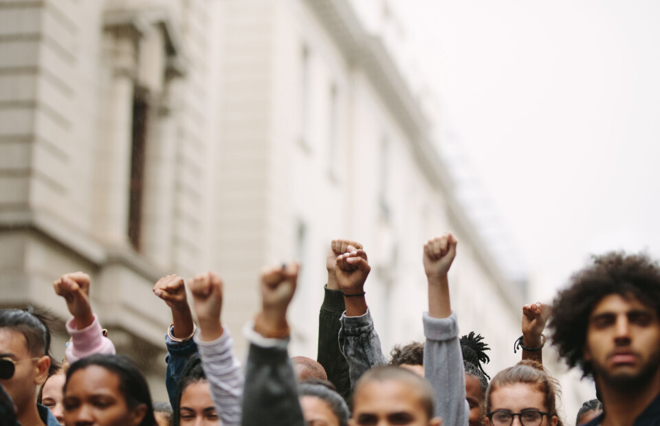 An image of striking workers on a march raising their fists in the air