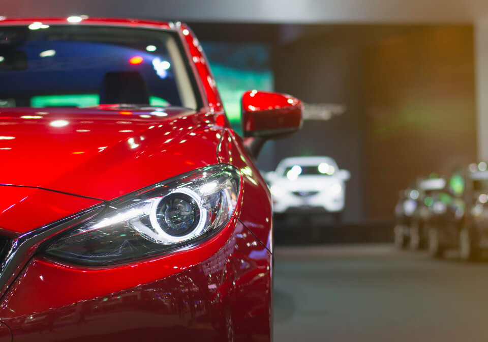 A shiny red car close up of its headlamp