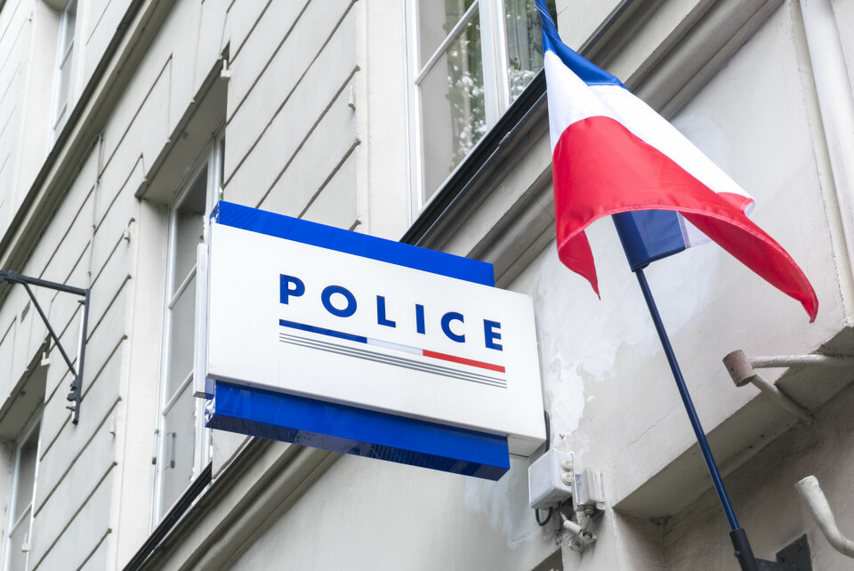 Sign on a building saying Police Nationale, with a French flag flying