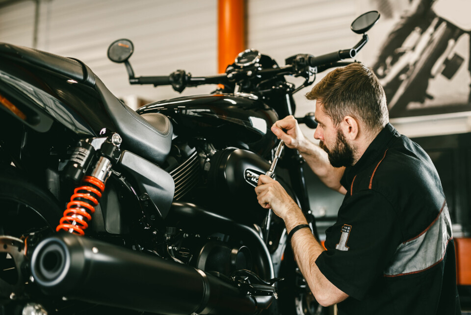 A photo of a mechanic checking up a motorbike