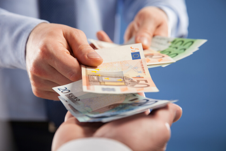 A businessman handing over euros in cash