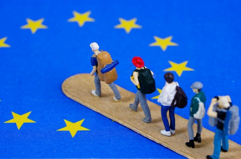 An EU flag with models of people walking into it, to show easier migration