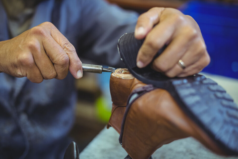 A cobbler repairing a sole on a boot