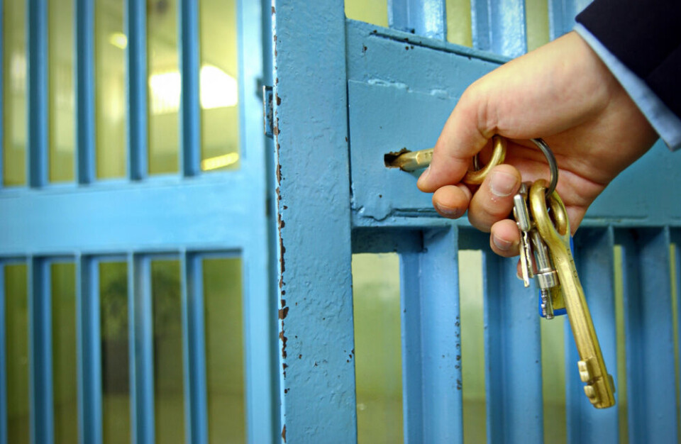 A view of a prison officer locking a prison gate