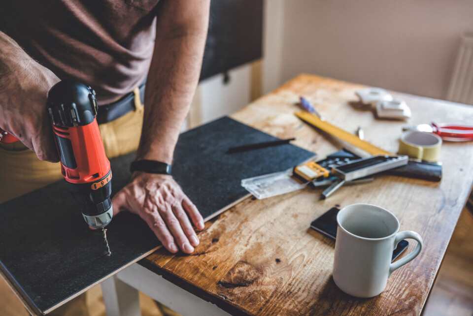 A view of a builder using a drill on a building project