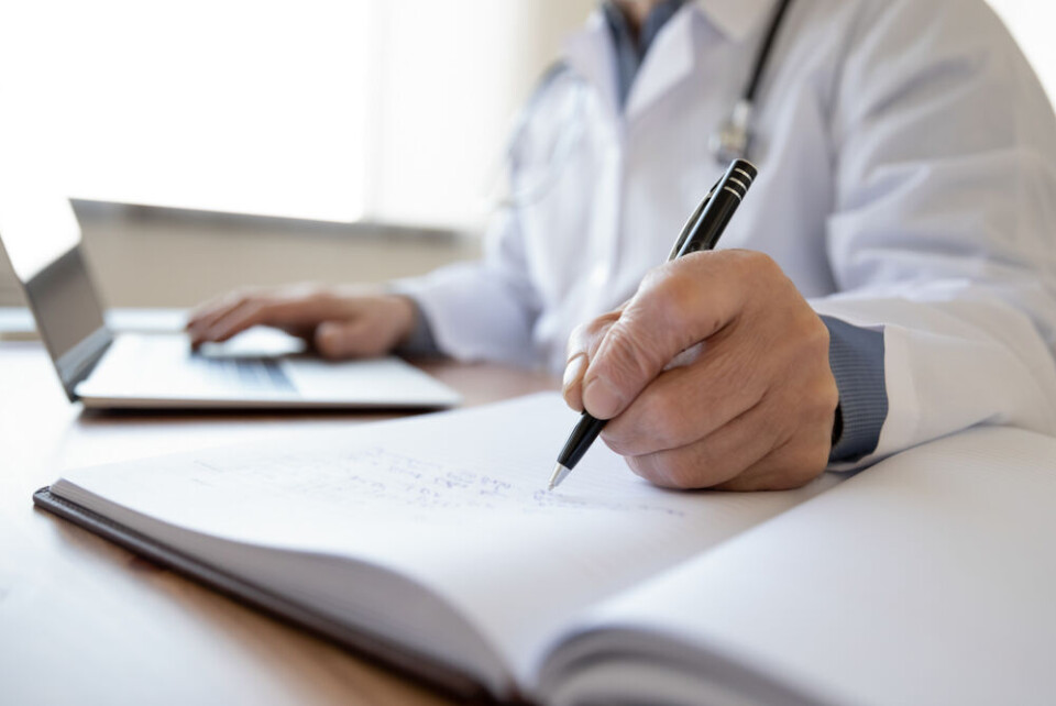 fizkes / Shutterstock A doctor filling out a patient form while using a laptop computer