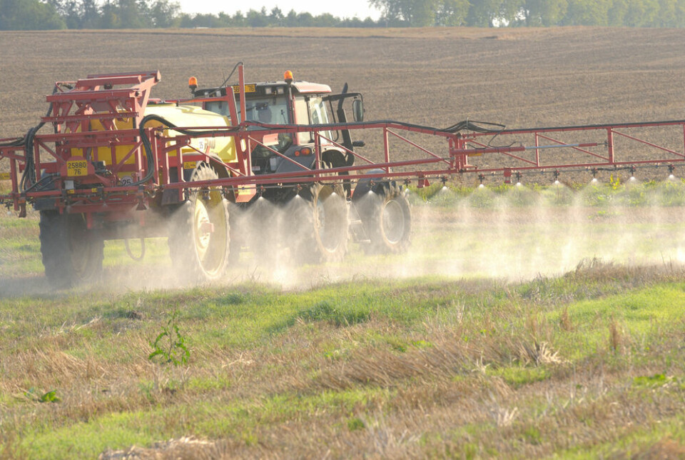 A view of a tractor spreading herbicide onto a field in Normandy, France