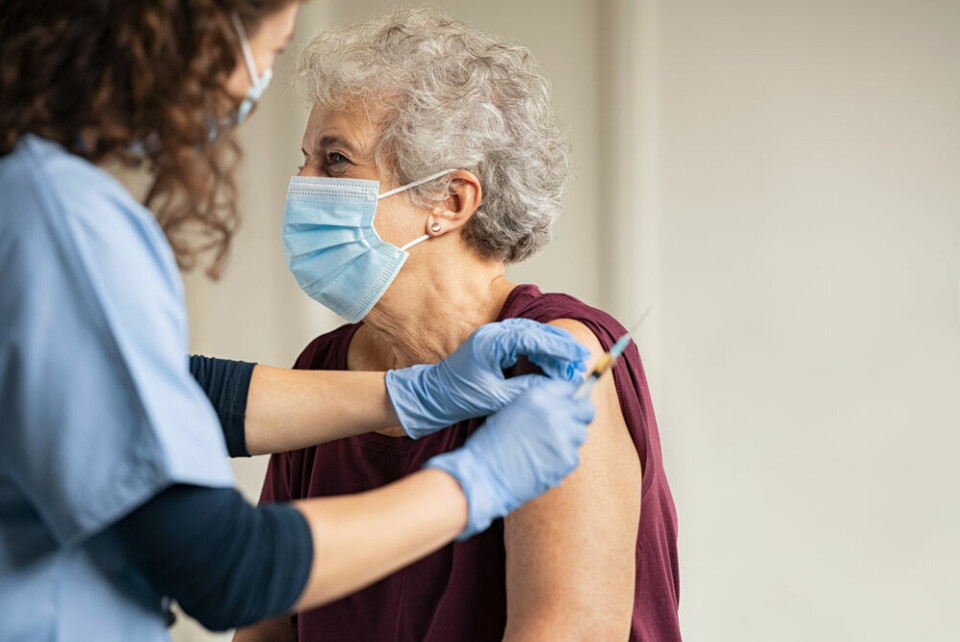 A view of an older woman receiving a Covid vaccination