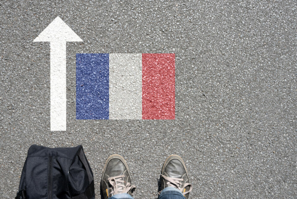 A view of a man with a bag looking down to the floor with an arrow pointing towards a French flag to suggest access to France