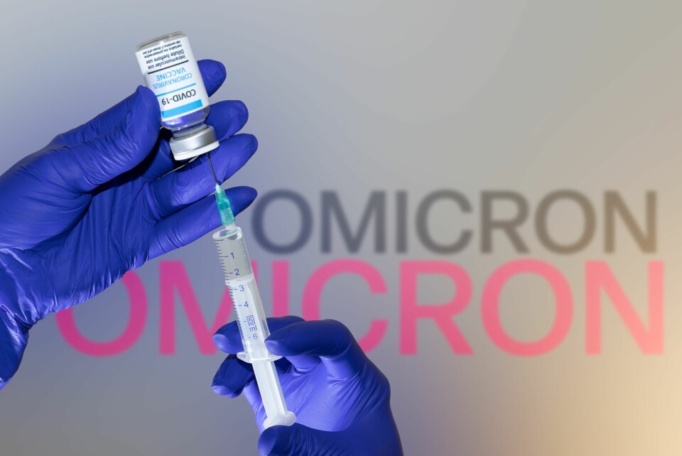A photo of someone wearing gloves and getting a syringe ready with a Covid vaccine, with the word Omicron in the background