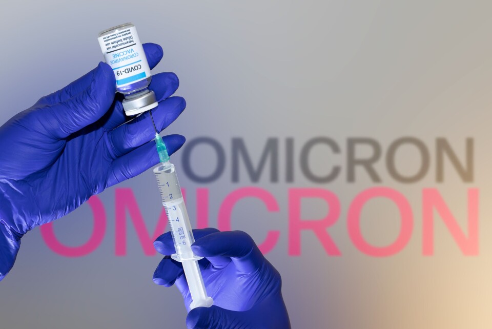 A photo of someone wearing gloves and getting a syringe ready with a Covid vaccine, with the word Omicron in the background