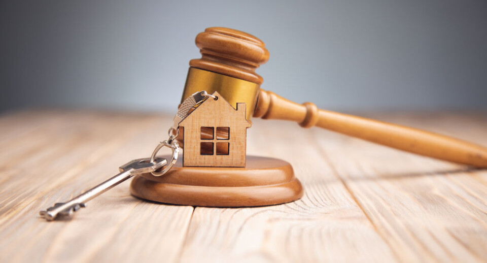Tiko Aramyan / Shutterstock A judge’s or auctioneer’s gavel with a model of a house and keys