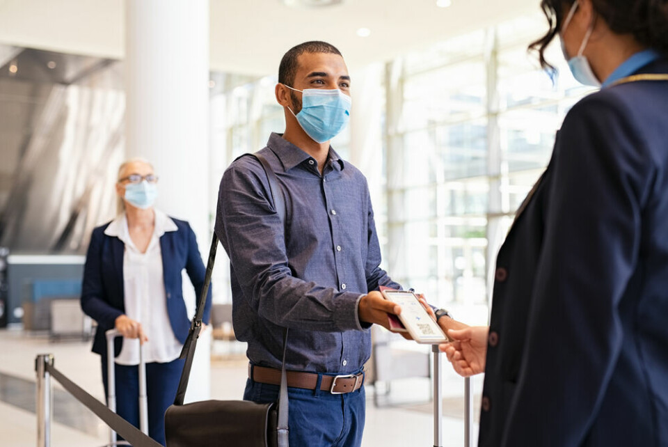 A man shows his vaccine pass to a staff member at an airport