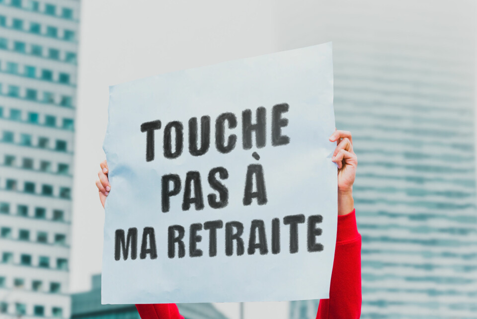 A protester holds a sign saying ‘Touche pas a ma retraite’, meaning ‘Don’t touch my retirement [pension]’
