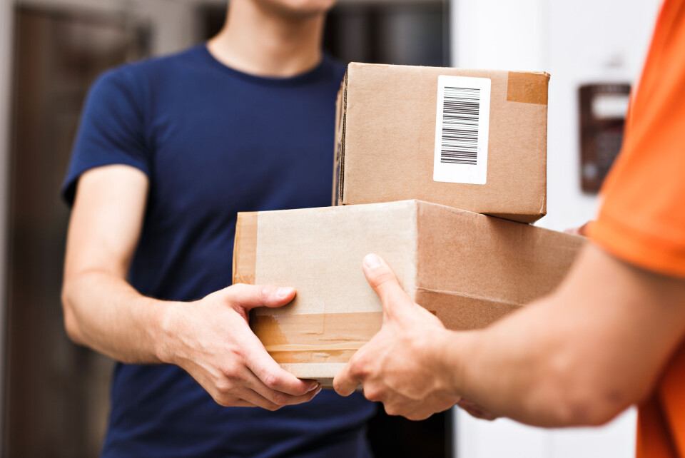 A photo of a man taking in two parcels from a delivery service