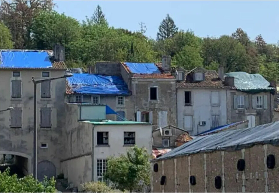 Homes in the town of Ribérac with blue tarpaulins over their roofs