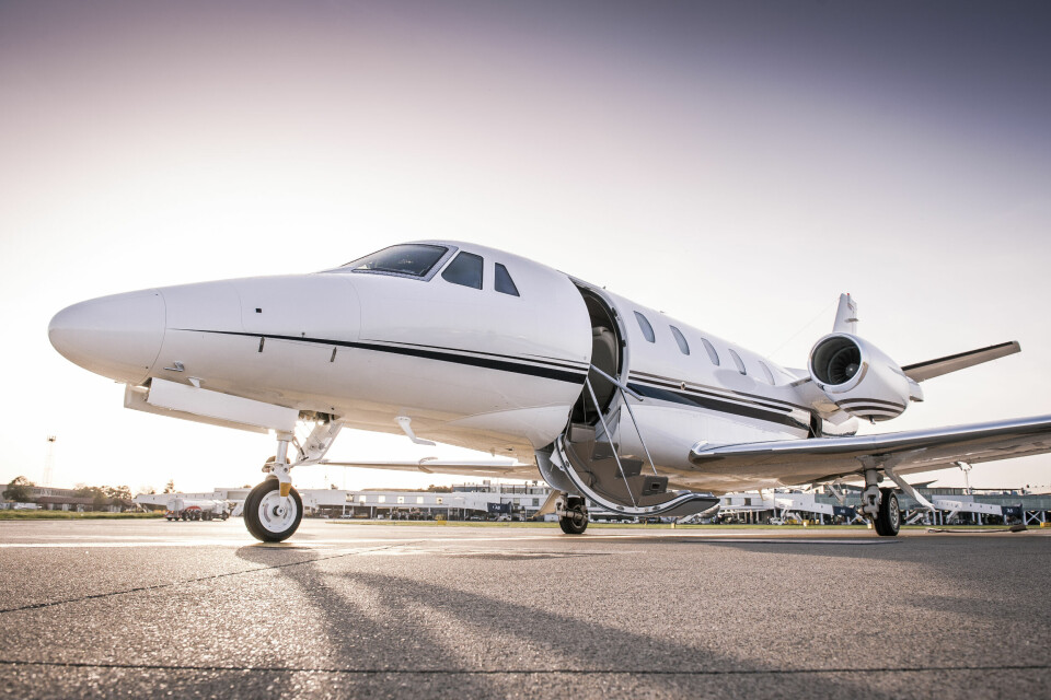 A photo of a private jet on airport concrete with its door open